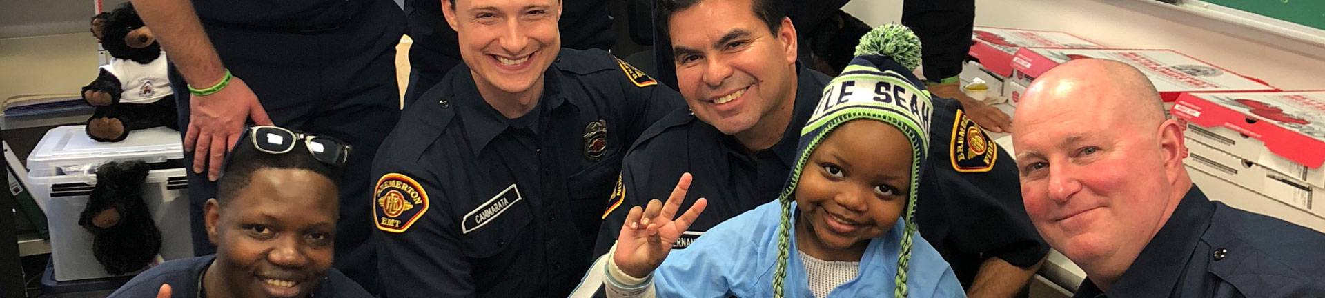 Fire fighters with little boy in hospital