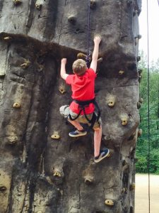 Camp-Eyabsut boy climbing rock